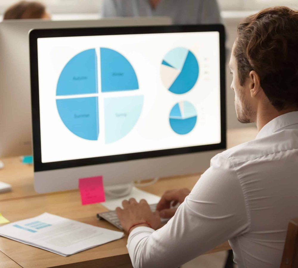 Focused,Businessman,Working,On,Statistics,Report,Using,Computer,In,Coworking